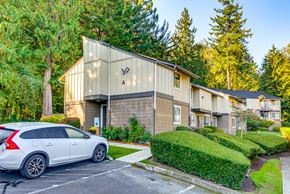 Issaquah apartment for rent - A white car is parked in front of a building with a tree in front of it.