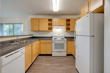 Issaquah apartment for rent - A kitchen with wooden cabinets and white appliances.