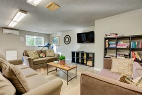 Kirkland apartment for rent - A living room with a brown couch, a coffee table, and a bookshelf.