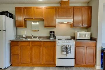 Kirkland apartment for rent - A kitchen with wooden cabinets and a white stove.