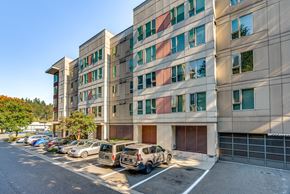 Kirkland apartment for rent - A parking lot in front of a multi-story building.
