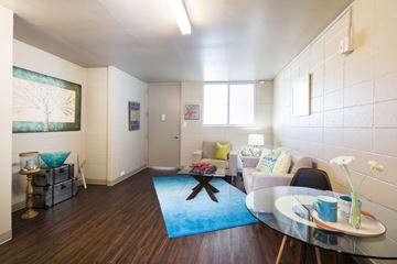 Honolulu apartment for rent - A living room with a blue rug and a glass table.