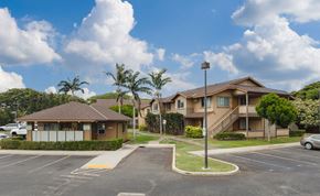 Kapolei apartment for rent - a row of houses with cars parked in a parking lot