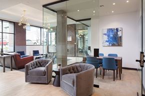 Seattle apartment for rent - a lounge area with chairs and tables in a room with glass walls