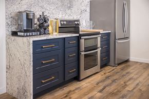 Vernal apartment for rent - A kitchen with dark blue drawers and a marble countertop.