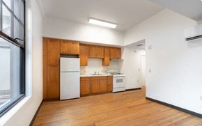 Honolulu apartment for rent - an empty kitchen with white appliances and wooden cabinets