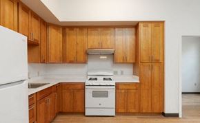 Honolulu apartment for rent - a kitchen with wooden cabinets and a white stove