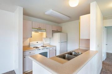 Kapolei apartment for rent - an empty kitchen with white appliances and a sink