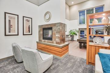 Kirkland apartment for rent - A living room with a grey carpet and a stone fireplace.