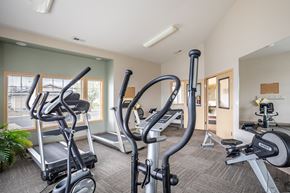Ellensburg apartment for rent - a gym with cardio equipment and weights at the enclave apartments