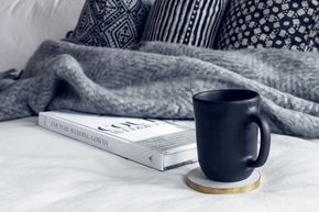 Bellingham apartment for rent - a blue coffee mug sitting next to a book on a bed