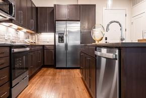 Denver apartment for rent - A modern kitchen with dark wood cabinets and stainless steel appliances.