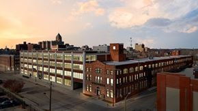 Detroit apartment for rent - A large building with a lot of windows is in the foreground.
