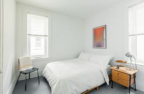 Detroit apartment for rent - a bedroom with a bed and a dresser and two windows
