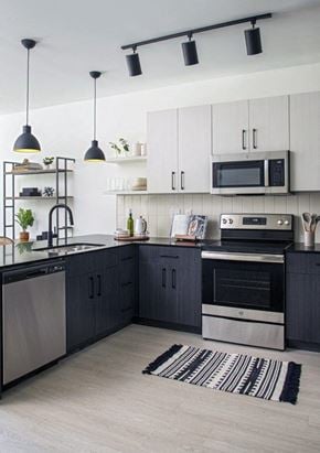 Detroit apartment for rent - a black and white kitchen with stainless steel appliances and white cabinets