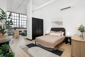 Detroit apartment for rent - a bedroom with a bed and a large window