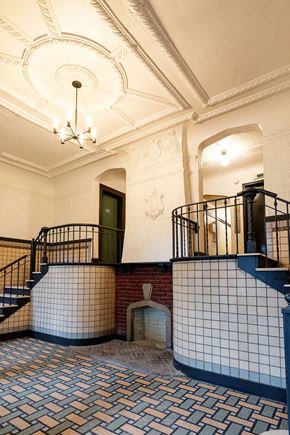 Detroit apartment for rent - the lobby of a building with stairs and a blue and white tiled floor