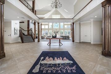 Novi apartment for rent - A large open living room with a blue carpet that says Central Park Estates.
