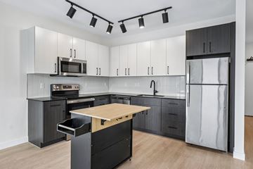 Detroit apartment for rent - A modern kitchen with a wooden island and stainless steel appliances.