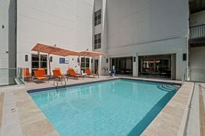 West Bloomfield apartment for rent - the pool area of a building with a pool and orange chairs