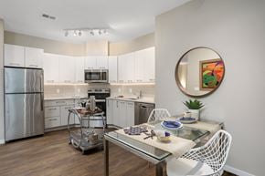 West Bloomfield apartment for rent - a kitchen with white cabinets and stainless steel appliances and a dining table