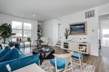 Novi apartment for rent - A living room with a blue couch and a painting on the wall.