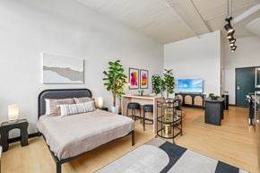 Detroit apartment for rent - A bedroom with a large bed and a desk with a chair.
