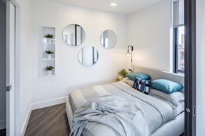 Washington apartment for rent - A bedroom with a bed, a nightstand, and three mirrors on the wall.