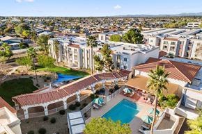 Peoria apartment for rent - A large white building with a pool in the middle of a courtyard.