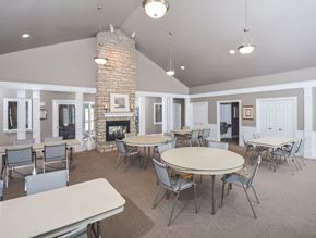 Toledo apartment for rent - A spacious room with a stone fireplace and multiple tables and chairs.