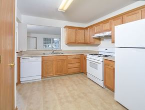 Toledo apartment for rent - A kitchen with wooden cabinets and white appliances.
