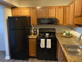 Indianapolis apartment for rent - a kitchen with black appliances and wooden cabinets