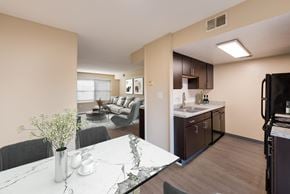 Columbus townhouse for rent - A kitchen with a refrigerator on the right and a dining table with chairs in the middle.