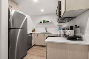 Peoria apartment for rent - A modern kitchen with a stainless steel refrigerator and wooden cabinets.