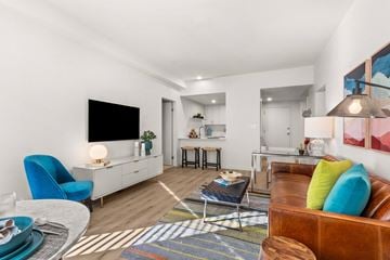 Peoria apartment for rent - A living room with a blue chair and a brown couch.
