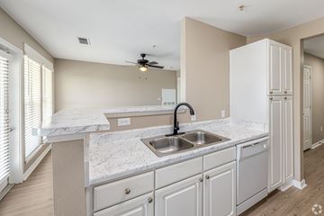 Gulfport apartment for rent - A kitchen with a marble countertop and white cabinets.