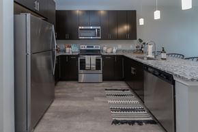 Detroit apartment for rent - A modern kitchen with a stainless steel refrigerator and black cabinets.