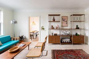 Detroit apartment for rent - A living room with a blue sofa, wooden coffee table, and a rug.