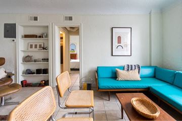 Detroit apartment for rent - A living room with a blue couch and a wooden coffee table.