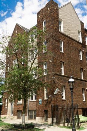 Detroit apartment for rent - A tall brick building with a tree in front of it.