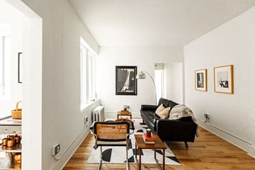 Detroit apartment for rent - a living room with a black couch and a table