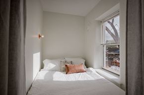 Detroit apartment for rent - a small bedroom with a bed and a window