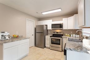 Gulfport apartment for rent - a kitchen with white cabinets and stainless steel appliances