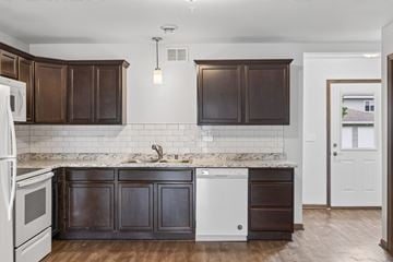 Jordan townhouse for rent - A kitchen with dark brown cabinets and a white fridge.
