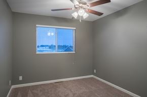 Eagle Lake townhouse for rent - an empty bedroom with a large window and a ceiling fan