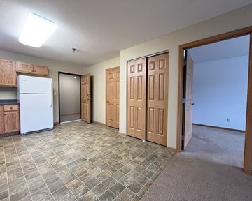 Jackson apartment for rent - A kitchen with a white refrigerator and wooden cabinets.