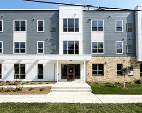 Austin apartment for rent - A modern building with a white and grey exterior and a black door.