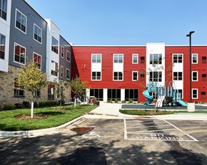 Austin apartment for rent - A red and white building with a playground in front.