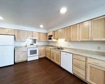 Austin apartment for rent - A kitchen with wooden cabinets and white appliances.