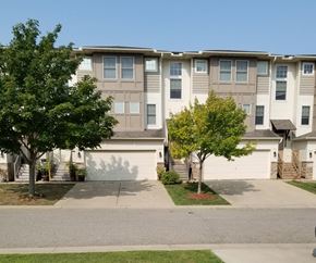 Faribault townhouse for rent - Apartment building with a tree in front of it.